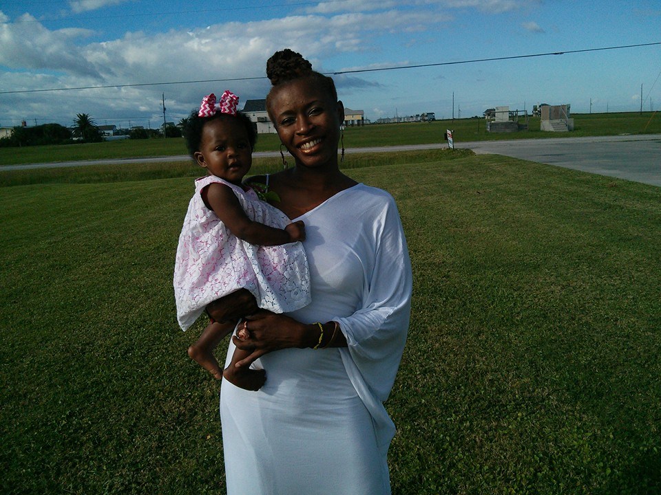 Nkoyo Ojuok the black doula wearing white with her infant outside on the lawn